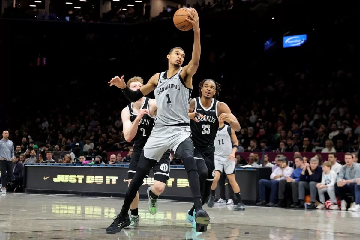 Feb 26, 2026; Brooklyn, New York, USA; San Antonio Spurs forward Victor Wembanyama (1) drives to the basket against Brooklyn Nets forward Danny Wolf (2) and center Nic Claxton (33) during the second quarter at Barclays Center. Mandatory Credit: Brad Penner-Imagn Images