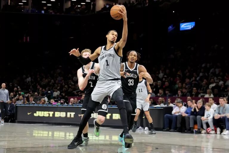 Feb 26, 2026; Brooklyn, New York, USA; San Antonio Spurs forward Victor Wembanyama (1) drives to the basket against Brooklyn Nets forward Danny Wolf (2) and center Nic Claxton (33) during the second quarter at Barclays Center. Mandatory Credit: Brad Penner-Imagn Images