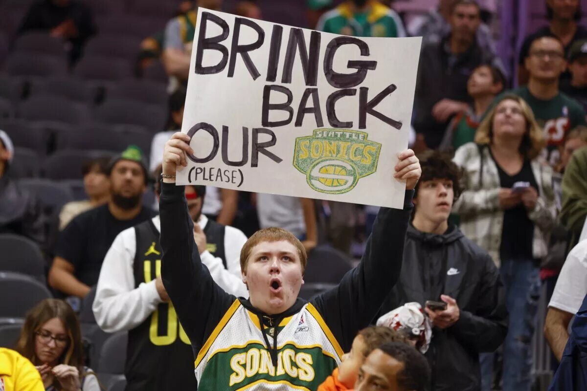 Oct 10, 2023; Seattle, Washington, USA; A Seattle Supersonics fan holds a sign advocating for their return during pregame warmups between the LA Clippers and Utah Jazz at Climate Pledge Arena. Mandatory Credit: Joe Nicholson-USA TODAY Sports