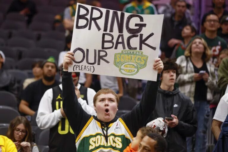 Oct 10, 2023; Seattle, Washington, USA; A Seattle Supersonics fan holds a sign advocating for their return during pregame warmups between the LA Clippers and Utah Jazz at Climate Pledge Arena. Mandatory Credit: Joe Nicholson-USA TODAY Sports