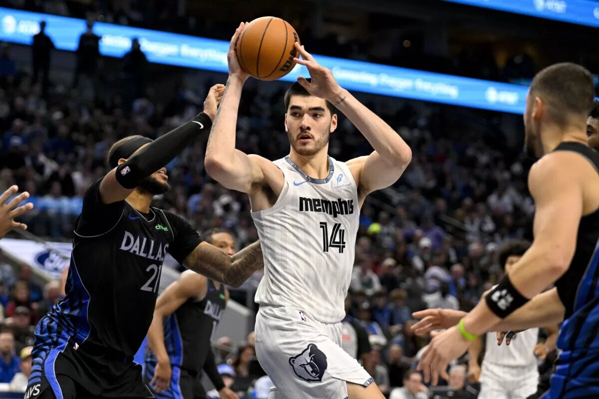 Nov 22, 2025; Dallas, Texas, USA; Memphis Grizzlies center Zach Edey (14) looks to pass the ball by Dallas Mavericks forward Daniel Gafford (21) during the game between the Mavericks and the Grizzlies at American Airlines Center. Mandatory Credit: Jerome Miron-Imagn Images
