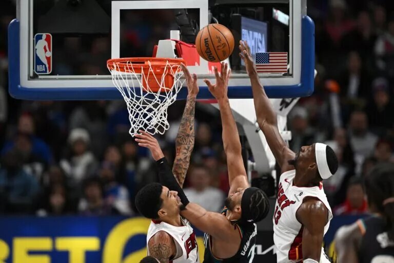 Jan 1, 2026; Detroit, Michigan, USA; Detroit Pistons guard Cade Cunningham (2) shoots the ball between Miami Heat centers Kel'El Ware (left) and Bam Adebayo (13) in the third quarter at Little Caesars Arena. Mandatory Credit: Lon Horwedel-Imagn Images