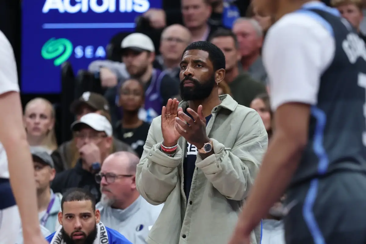 Jan 8, 2026; Salt Lake City, Utah, USA; Dallas Mavericks guard Kyrie Irving (11) watches play against the Utah Jazz in street clothes during the first half of the game at Delta Center.