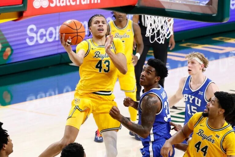 Feb 10, 2026; Waco, Texas, USA; Baylor Bears guard Cameron Carr (43) drives to the basket for a layup past BYU Cougars guard Robert Wright III (1) during the second half at Paul and Alejandra Foster Pavilion. Mandatory Credit: Chris Jones-Imagn Images