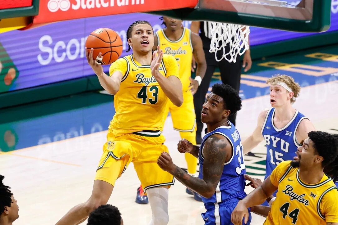 Feb 10, 2026; Waco, Texas, USA; Baylor Bears guard Cameron Carr (43) drives to the basket for a layup past BYU Cougars guard Robert Wright III (1) during the second half at Paul and Alejandra Foster Pavilion. Mandatory Credit: Chris Jones-Imagn Images