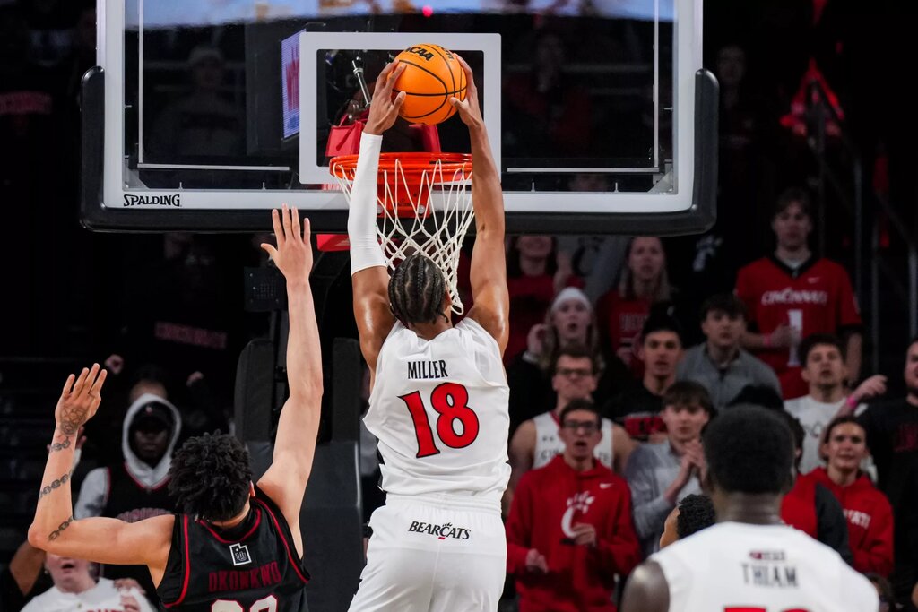 Feb 15, 2026; Cincinnati, Ohio, USA; Cincinnati Bearcats forward Baba Miller (18) dunks the ball against Utah Utes forward James Okonkwo (32) in the second at Fifth Third Arena. Mandatory Credit: Aaron Doster-Imagn Images
