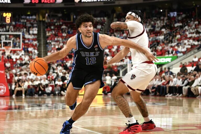 Duke Blue Devils forward Cameron Boozer (12) drives the ball around NC State Wolfpack forward Darrion Williams (1) during the first half at Lenovo Center.