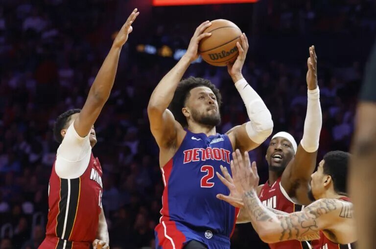 Detroit Pistons guard Cade Cunningham goes up for shot against Miami Heat defenders