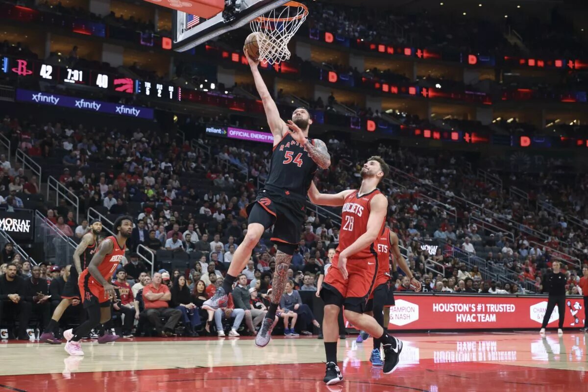 Toronto Raptors forward Sandro Mamukelashvili (54) scores a basket as Houston Rockets center Alperen Sengun (28) defends during the second quarter at Toyota Center.