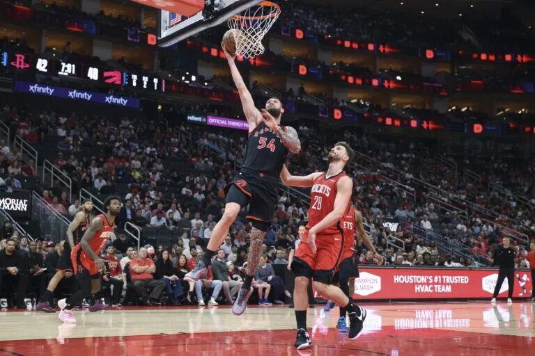 Toronto Raptors forward Sandro Mamukelashvili (54) scores a basket as Houston Rockets center Alperen Sengun (28) defends during the second quarter at Toyota Center.