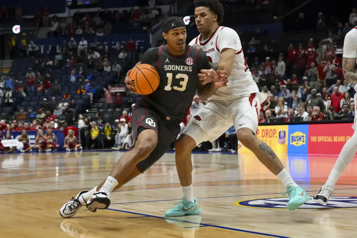 Mar 13, 2026; Nashville, TN, USA; Oklahoma Sooners forward Tae Davis (13) shoots over Arkansas Razorbacks forward Malique Ewin (12) during the second half at Bridgestone Arena. Mandatory Credit: Steve Roberts-Imagn Images