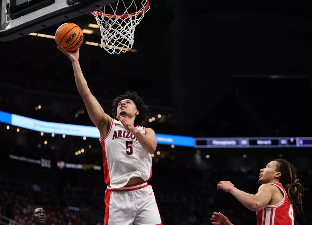 Arizona Wildcats guard Brayden Burries (5) drives to the hoop past Houston Cougars guard Kingston Flemings (4) during the first half during the men's Big 12 Conference Tournament Championship at T-Mobile Center.