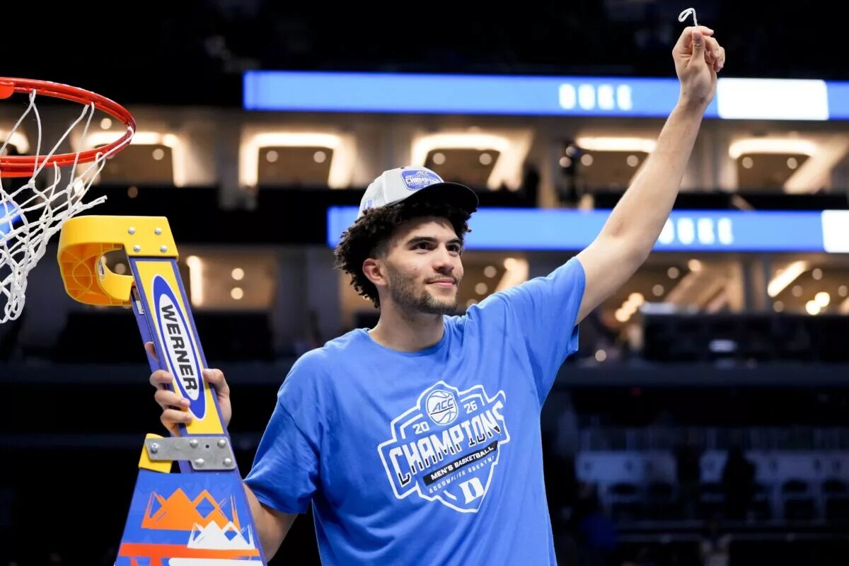 Duke Blue Devils forward Cameron Boozer (12) cuts down the net after defeating the Virginia Cavaliers in the men's ACC Conference Tournament Championship at Spectrum Center.