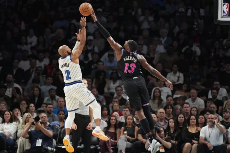 Mar 14, 2026; Miami, Florida, USA; Miami Heat center Bam Adebayo (13) blocks the shot of Orlando Magic guard Jevon Carter (2) during the second half at Kaseya Center. Mandatory Credit: Jim Rassol-Imagn Images