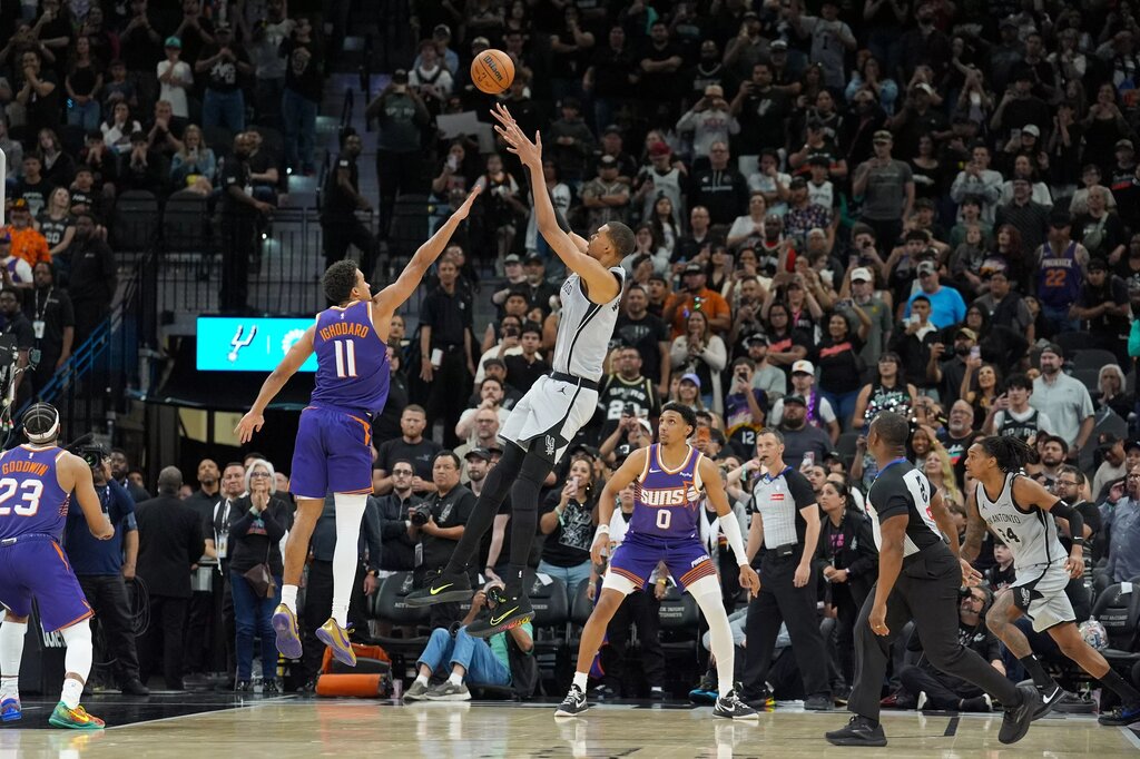 Mar 19, 2026; San Antonio, Texas, USA; San Antonio Spurs forward Victor Wembanyama (1) shoots the game winning shot over Phoenix Suns forward Oso Ighodaro (11) in the second half at Frost Bank Center. Mandatory Credit: Daniel Dunn-Imagn Images