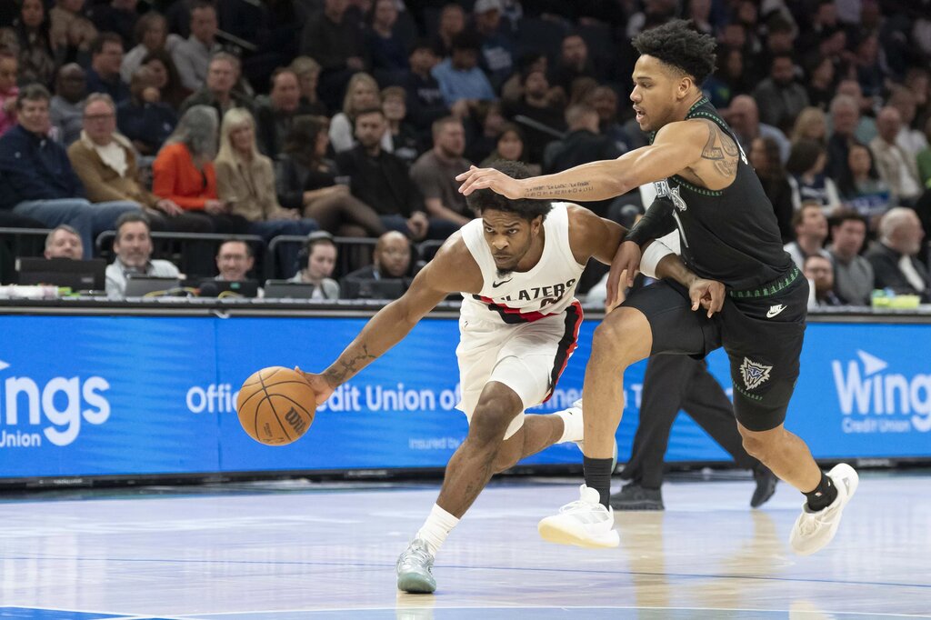  Portland Trail Blazers guard Scoot Henderson (00) dribbles the ball as Minnesota Timberwolves guard Terrence Shannon Jr. (1) plays defense in the first half at Target Center.