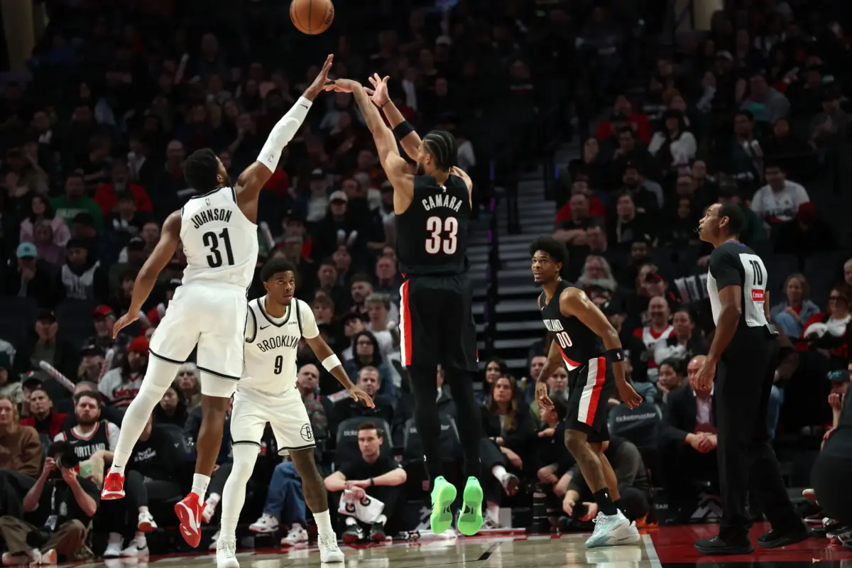 Mar 23, 2026; Portland, Oregon, USA; Portland Trail Blazers forward Toumani Camara (33) shoots the ball over Brooklyn Nets guard/forward Chaney Johnson (31) during the second half at Moda Center. Mandatory Credit: Jaime Valdez-Imagn Images