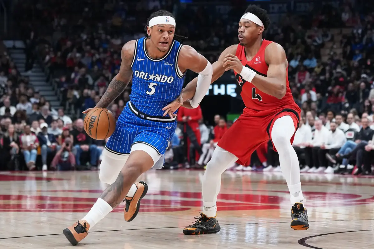 Orlando Magic forward Paolo Banchero (5) controls the ball as Toronto Raptors forward Scottie Barnes (4) tries to defend during the first quarter at Scotiabank Arena.