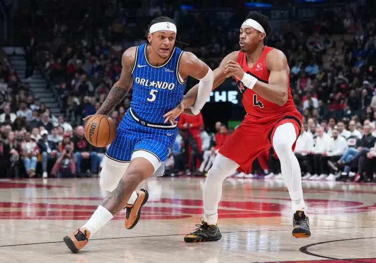 Orlando Magic forward Paolo Banchero (5) controls the ball as Toronto Raptors forward Scottie Barnes (4) tries to defend during the first quarter at Scotiabank Arena.