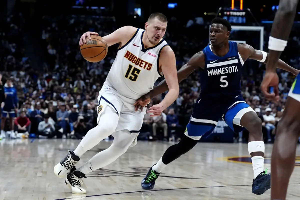 Minnesota Timberwolves guard Anthony Edwards (5) defends Denver Nuggets center Nikola Jokic (15) in the second half at Ball Arena.