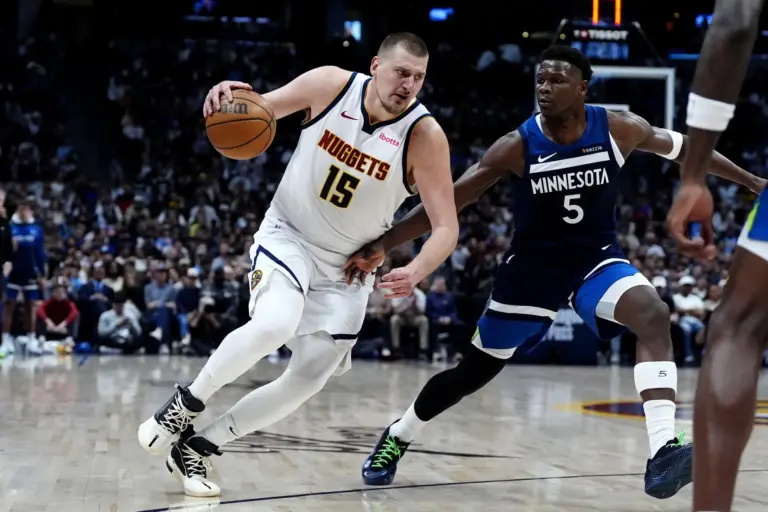 Minnesota Timberwolves guard Anthony Edwards (5) defends Denver Nuggets center Nikola Jokic (15) in the second half at Ball Arena.