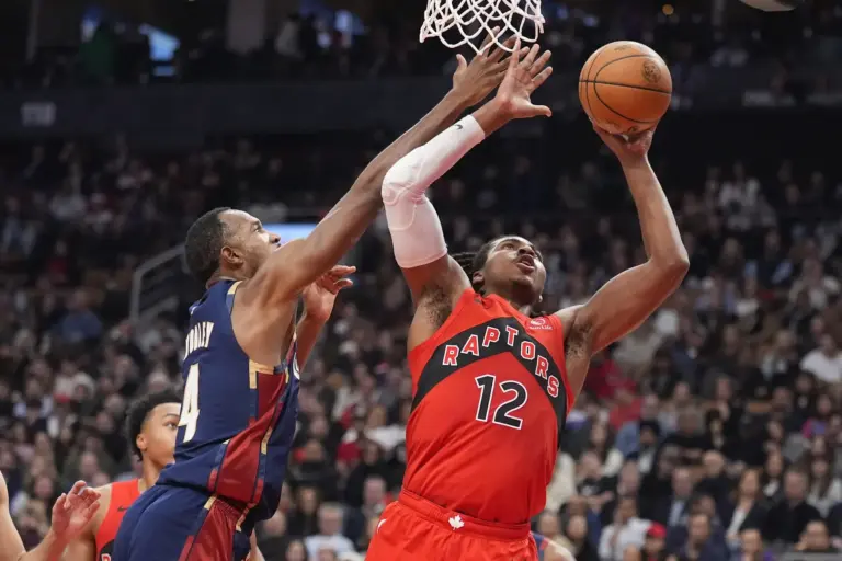 Nov 24, 2025; Toronto, Ontario, CAN; Toronto Raptors forward Collin Murray-Boyles (12) goes up to make a basket against Cleveland Cavaliers forward Evan Mobley (4) during the first half at Scotiabank Arena. Mandatory Credit: John E. Sokolowski-Imagn Images