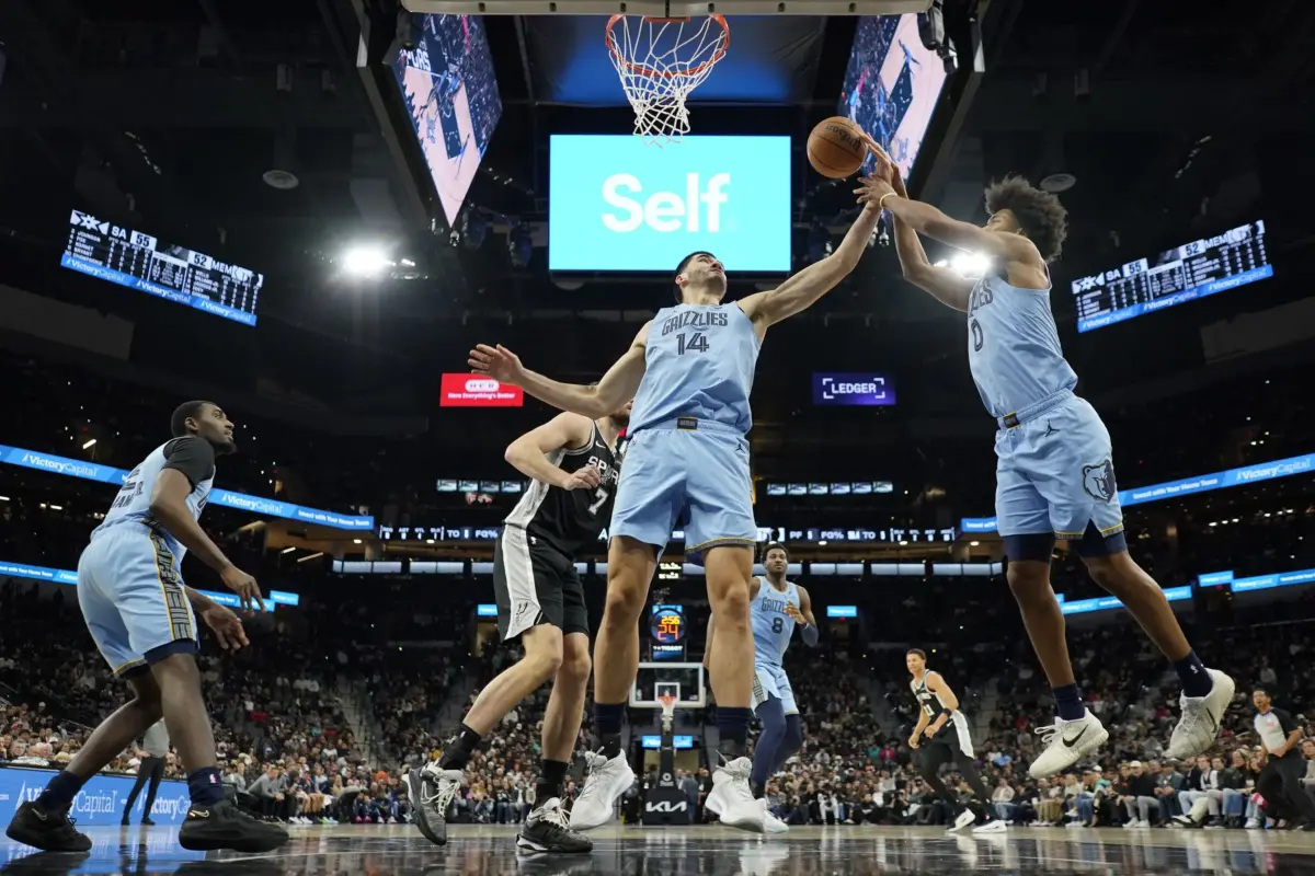 Memphis Grizzlies center Zach Edey (14) and guard Jaylen Wells (0) reach for a rebound during the first half against the San Antonio Spurs at Frost Bank Center.