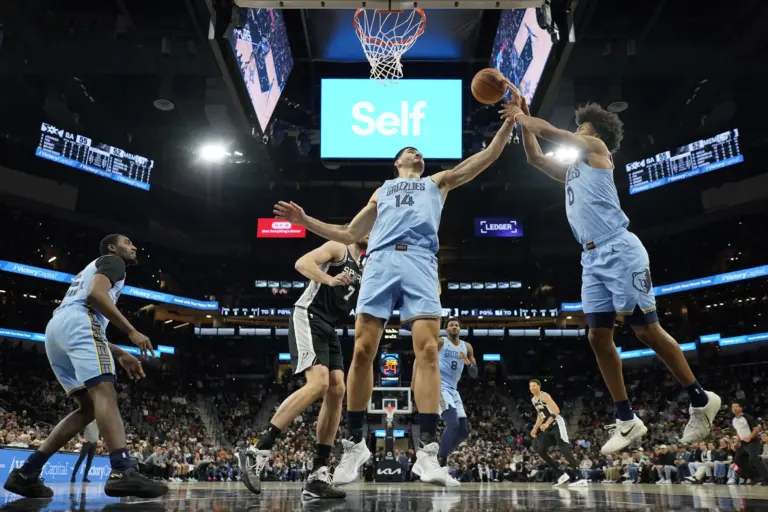 Memphis Grizzlies center Zach Edey (14) and guard Jaylen Wells (0) reach for a rebound during the first half against the San Antonio Spurs at Frost Bank Center.
