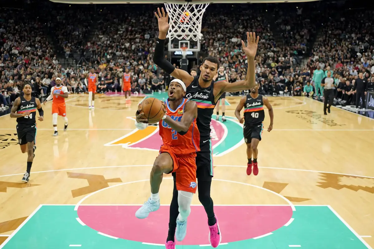 Oklahoma City Thunder guard Shai Gilgeous-Alexander attempts to convert layup with San Antonio Spurs center Victor Wembanyama on his back to block the shot