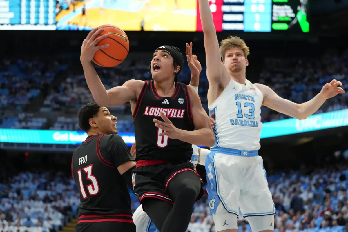 Feb 23, 2026; Chapel Hill, North Carolina, USA; Louisville Cardinals guard Mikel Brown Jr. (0) shoots as North Carolina Tar Heels center Henri Veesaar (13) defends in the first half at Dean E. Smith Center. Mandatory Credit: Bob Donnan-Imagn Images