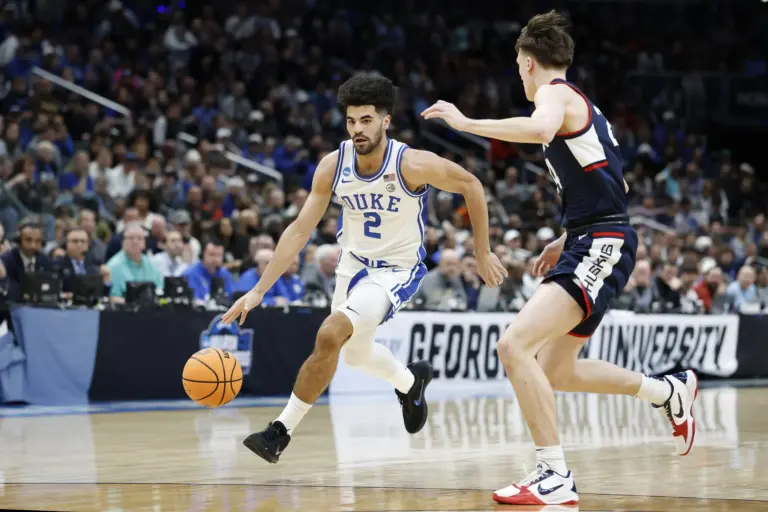 Duke Blue Devils guard Cayden Boozer (2) dribbles the ball as UConn Huskies guard Braylon Mullins (24) defends in the first half during an Elite Eight game of the East Regional of the men's 2026 NCAA Tournament at Capital One Arena.
