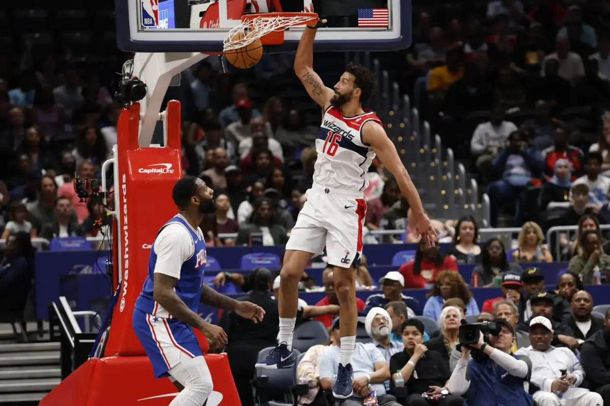 Apr 1, 2026; Washington, District of Columbia, USA; Washington Wizards forward Anthony Gill (16) dunks the ball as Philadelphia 76ers center Andre Drummond (1) looks on in the first half at Capital One Arena. Mandatory Credit: Geoff Burke-Imagn Images