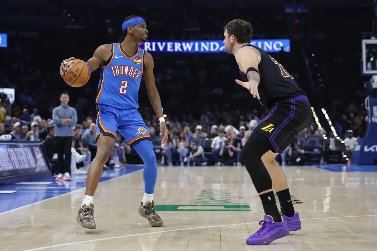 Oklahoma City Thunder guard Shai Gilgeous-Alexander (2) dribbles down the court as Los Angeles Lakers guard Luka Doncic (77) defends during the second half at Paycom Center.