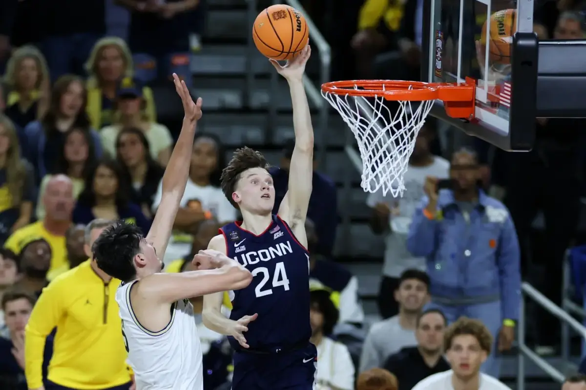 UConn Huskies guard Braylon Mullins (24) shoots past Michigan Wolverines center Aday Mara (15) in the first half during the national championship of the Final Four of the men's 2026 NCAA Tournament at Lucas Oil Stadium.