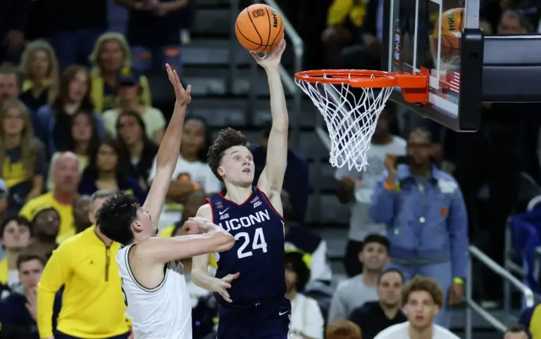 UConn Huskies guard Braylon Mullins (24) shoots past Michigan Wolverines center Aday Mara (15) in the first half during the national championship of the Final Four of the men's 2026 NCAA Tournament at Lucas Oil Stadium.