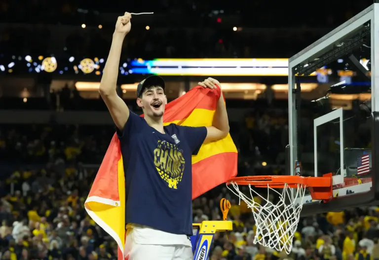 Michigan Wolverines center Aday Mara (15) celebrates after cutting down a piece of the net after defeating the Connecticut Huskies in the national championship of the Final Four of the men's 2026 NCAA Tournament at Lucas Oil Stadium.
