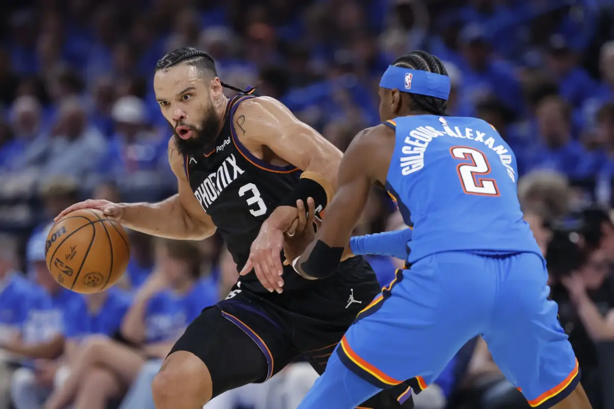 Phoenix Suns forward Dillon Brooks (3) drives around Oklahoma City Thunder guard Shai Gilgeous-Alexander (2) in the second quarter during game one of the first round of the 2026 NBA Playoffs at Paycom Center.