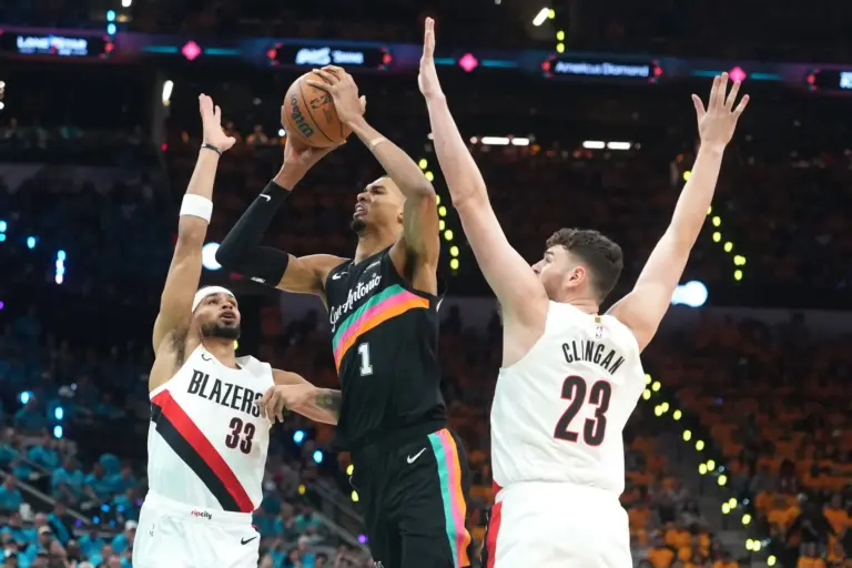 San Antonio Spurs forward Victor Wembanyama (1) drives to the basket between Portland Trail Blazers forward Toumani Camara (33) and center Donovan Clingan (23) during the first half of game one of the first round of the 2026 NBA Playoffs at Frost Bank Center.