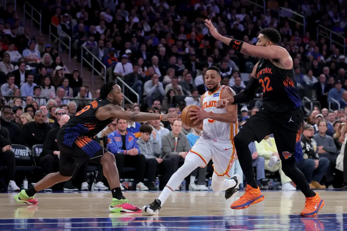 Atlanta Hawks guard CJ McCollum drives past two New York Knicks defender
