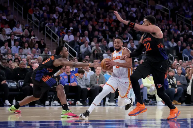 Atlanta Hawks guard CJ McCollum drives past two New York Knicks defender