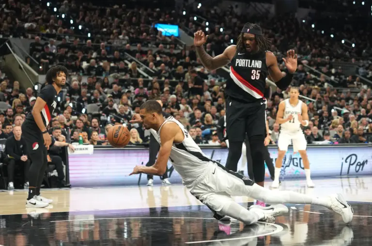 Apr 21, 2026; San Antonio, Texas, USA; San Antonio Spurs forward Victor Wembanyama (1) falls to the ground while driving to the basket past Portland Trail Blazers center Robert Williams III (35) during the first half of game two of the first round of the 2026 NBA Playoffs at Frost Bank Center. Mandatory Credit: Scott Wachter-Imagn Images