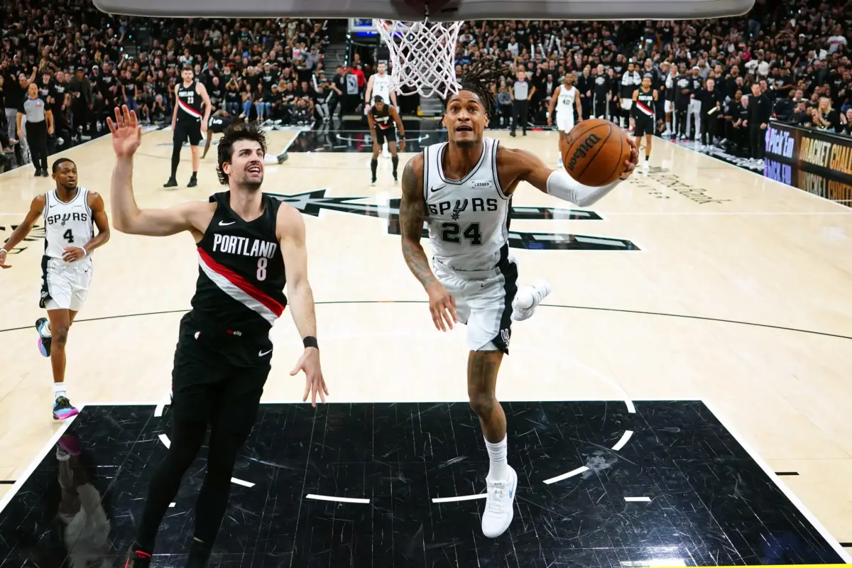 Apr 21, 2026; San Antonio, Texas, USA; San Antonio Spurs guard Devin Vassell (24) drives against Portland Trail Blazers forward Deni Avdija (8) during the second half of game two of the first round of the 2026 NBA Playoffs at Frost Bank Center. Mandatory Credit: Scott Wachter-Imagn Images