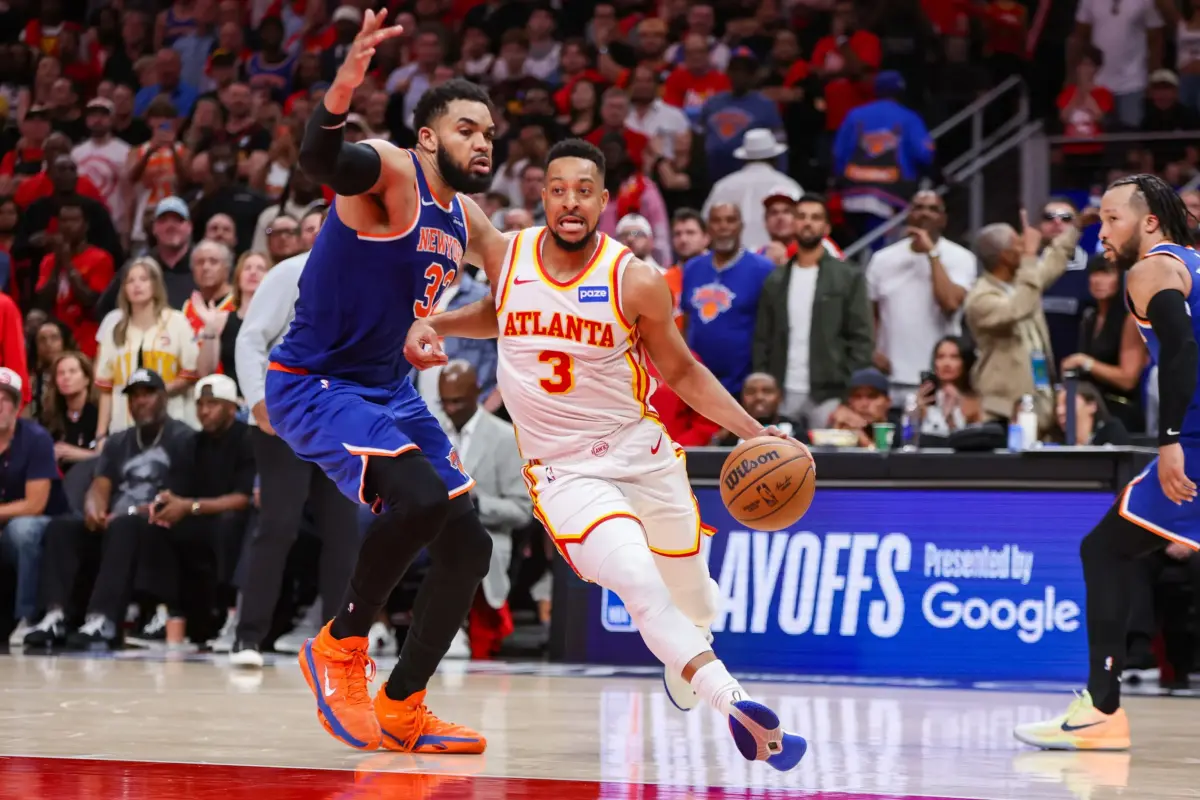 Atlanta Hawks guard CJ McCollum (3) drives past New York Knicks center Karl-Anthony Towns (32) in the fourth quarter during game three of the first round of the 2026 NBA Playoffs at State Farm Arena.