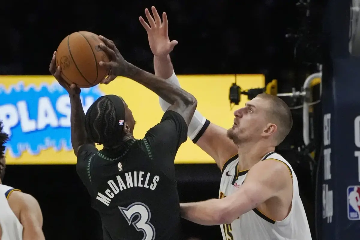 Apr 23, 2026; Minneapolis, Minnesota, USA; Minnesota Timberwolves forward Jaden McDaniels (3) shoots against Denver Nuggets center Nikola Jokic (15) in the fourth quarter at Target Center. Mandatory Credit: Bruce Kluckhohn-Imagn Images