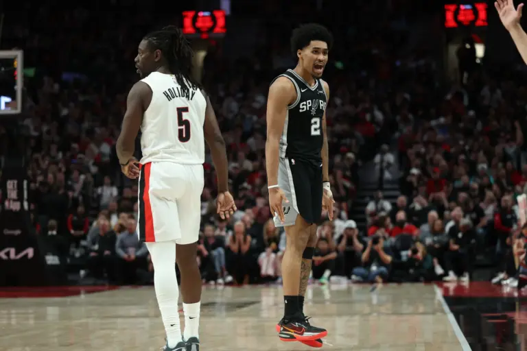 Apr 24, 2026; Portland, Oregon, USA; San Antonio Spurs guard Dylan Harper (2) reacts after scoring against Portland Trail Blazers guard Jrue Holiday (5) during the second half during game three of the first round of the 2026 NBA Playoffs at Moda Center. Mandatory Credit: Jaime Valdez-Imagn Images