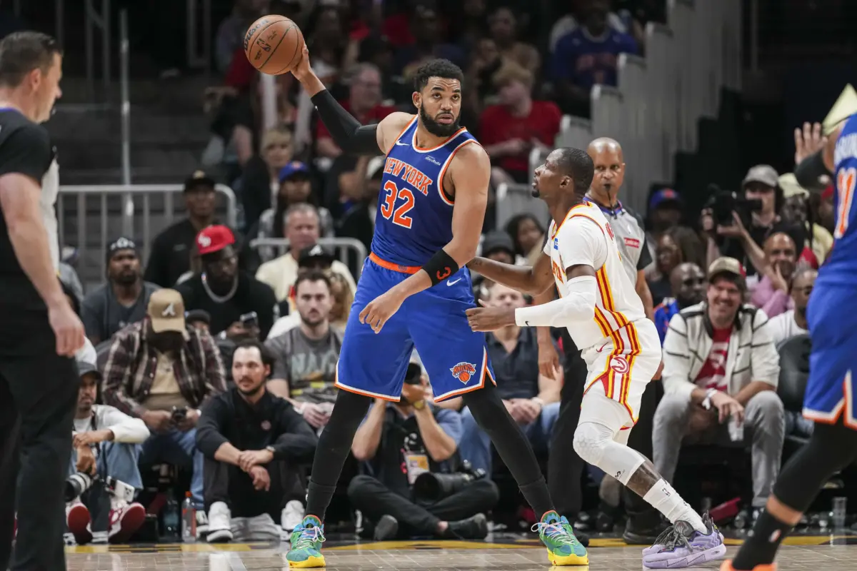 Apr 25, 2026; Atlanta, Georgia, USA; New York Knicks center Karl-Anthony Towns (32) holds the ball away from Atlanta Hawks forward Jonathan Kuminga (0) during the second half during game four of the first round of the 2026 NBA Playoffs at State Farm Arena. Mandatory Credit: Dale Zanine-Imagn Images