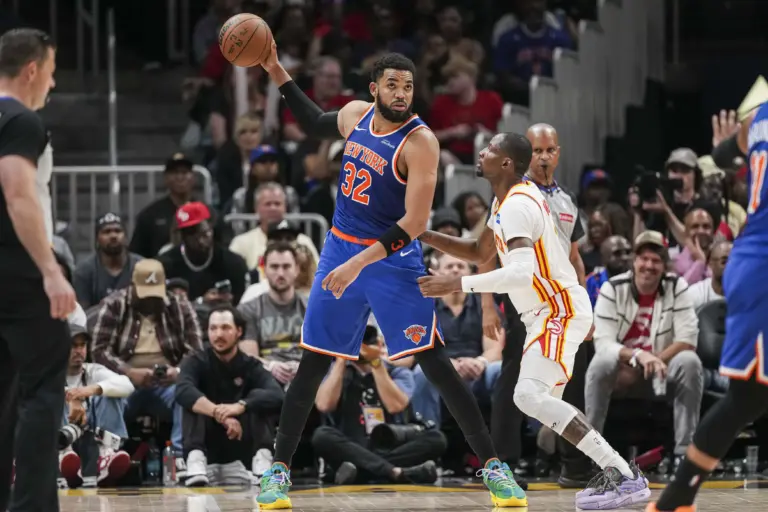 Apr 25, 2026; Atlanta, Georgia, USA; New York Knicks center Karl-Anthony Towns (32) holds the ball away from Atlanta Hawks forward Jonathan Kuminga (0) during the second half during game four of the first round of the 2026 NBA Playoffs at State Farm Arena. Mandatory Credit: Dale Zanine-Imagn Images
