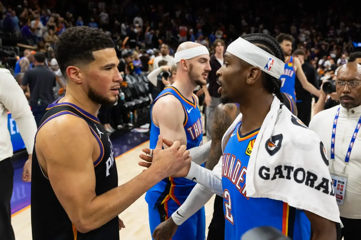 Oklahoma City Thunder guard Shai Gilgeous-Alexander (2) greets Phoenix Suns guard Devin Booker (1) after advancing in a four game sweep of the first round of the 2026 NBA Playoffs at Mortgage Matchup Center.