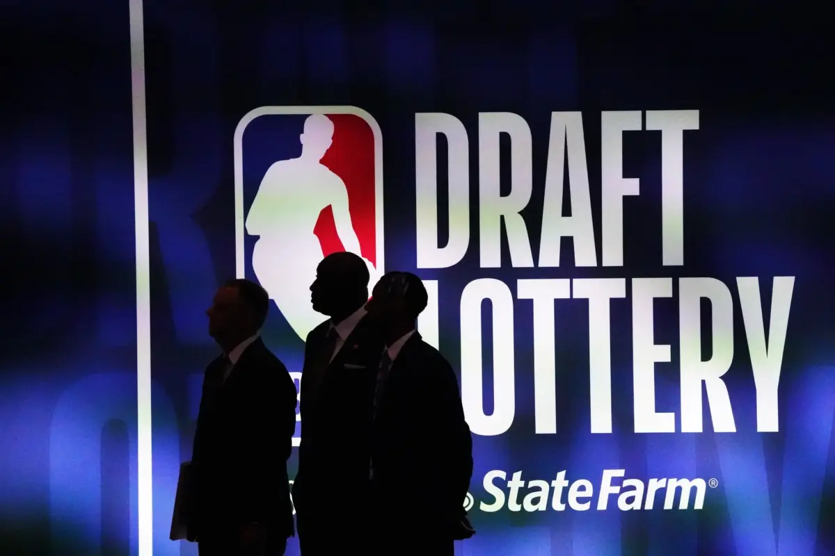 Three people walking in front of NBA Draft Lottery board (Washington Wizards article)