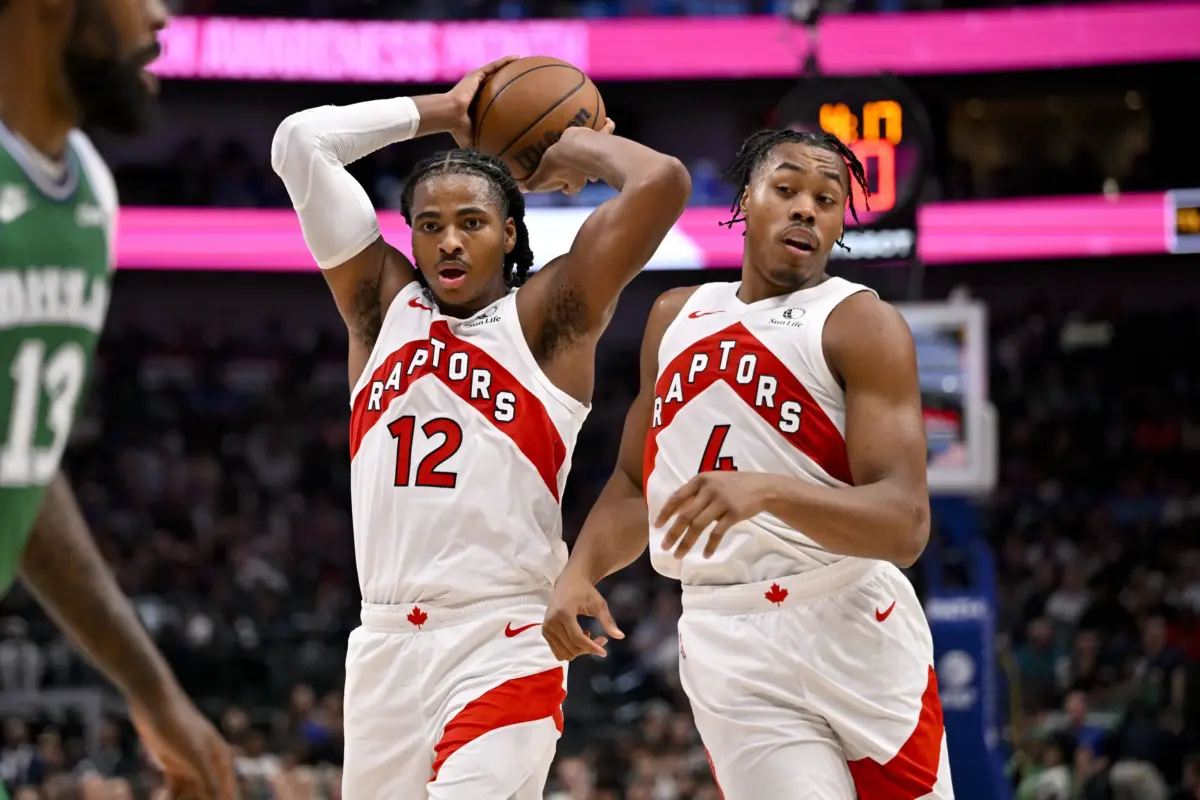 Toronto Raptors forward Collin Murray-Boyles (12) and forward Scottie Barnes (4) control the ball during the game between the Mavericks and the Raptors at the American Airlines Center.